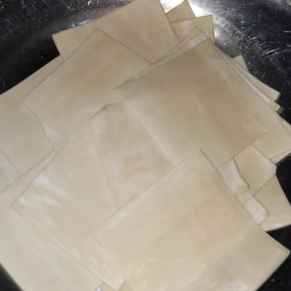 Potong 1 lembar kulit pangsit menjadi 4 bagian.