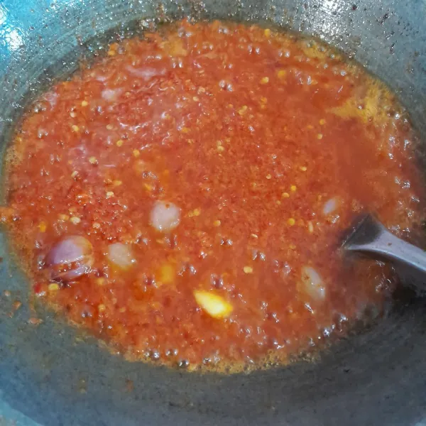 Panaskan minyak sayur dengan api sedang, tumis bumbu halus hingga tidak berbau langu. Masukkan bawang merah utuh, aduk rata.