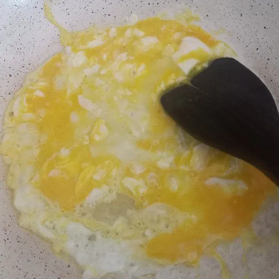 Orak arik telur hingga matang. Tumis bawang putih halus hingga harum.