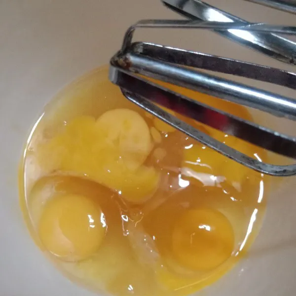 Campur gula, emulsifier, dan telur dalam wadah.