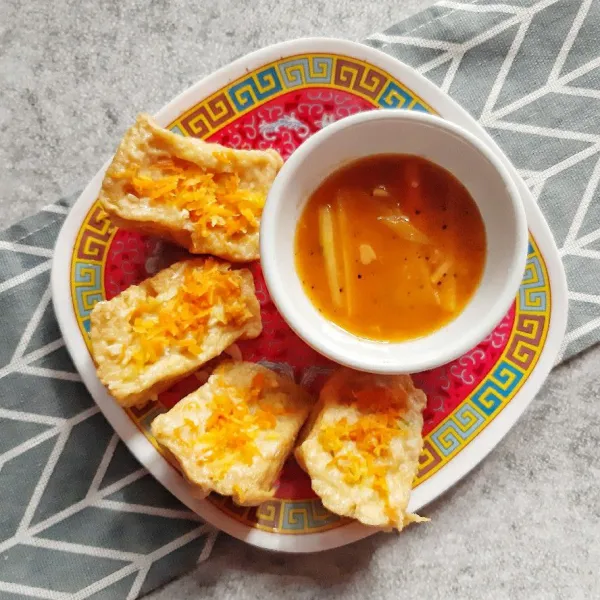 Letakkan tahu di piring saji dan saus di wadah terpisah lalu sajikan.