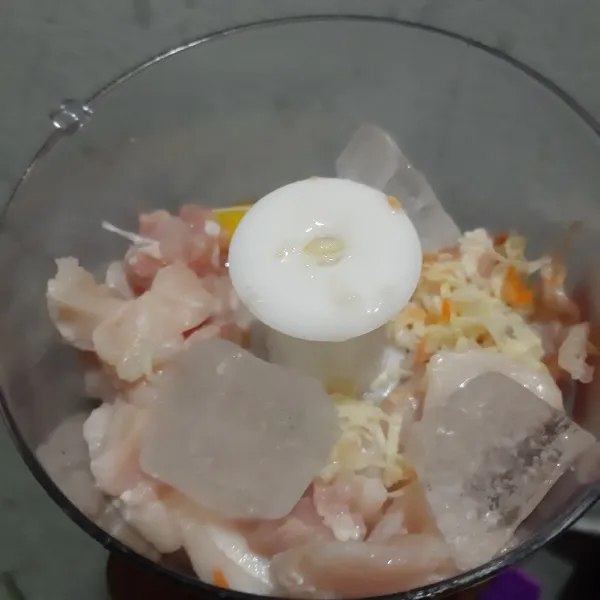 Blender paha ayam, dada ayam, bawang putih parut dan es batu.