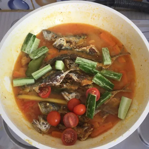 Masukkan ikan yang sudah digoreng, tomat, timun dan daun kemangi. Masak sekitar 2 menit. Matikan api.