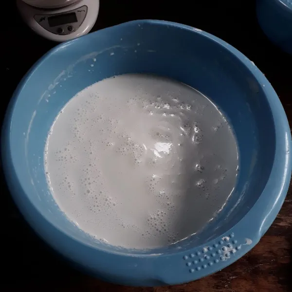 Tambahkan santan dan air secara bertahap sambil diuleni hingga rata dan gula larut.