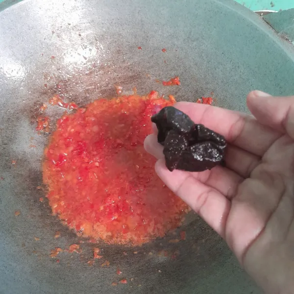 Masakukan cabe merah giling ke minyak panas, tambahkan kaldu bubuk dan asam kandis , masak sampai bau langu cabe hilang .