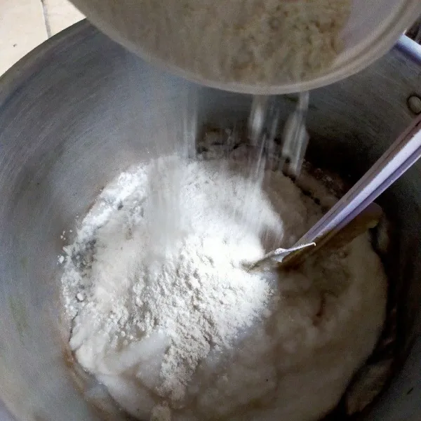 Tuang nasi yang sudah dihaluskan dalam panci kemudian tambahkan tepung terigu, aduk rata.