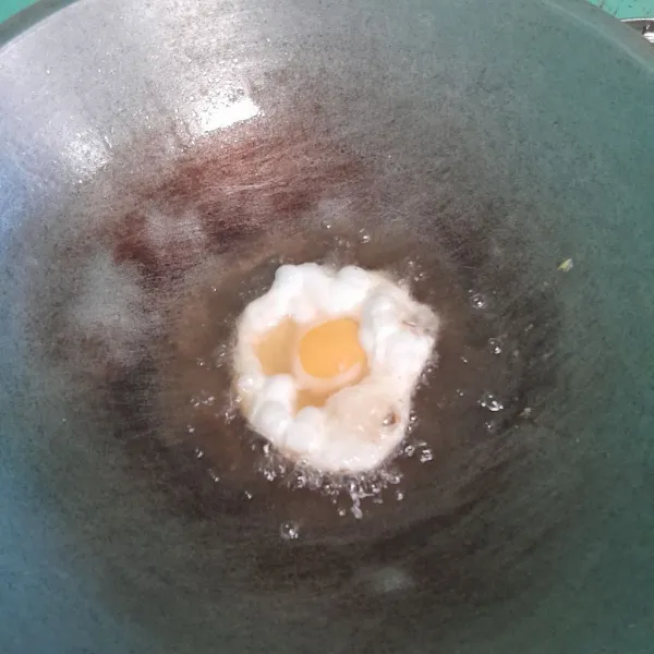 Pecahkan telur, lalu beri garam, masak telur sampai ke dua sisi matang.