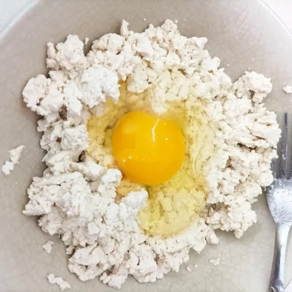 Haluskan tahu dengan garpu, kemudian tambahkan telur aduk rata.