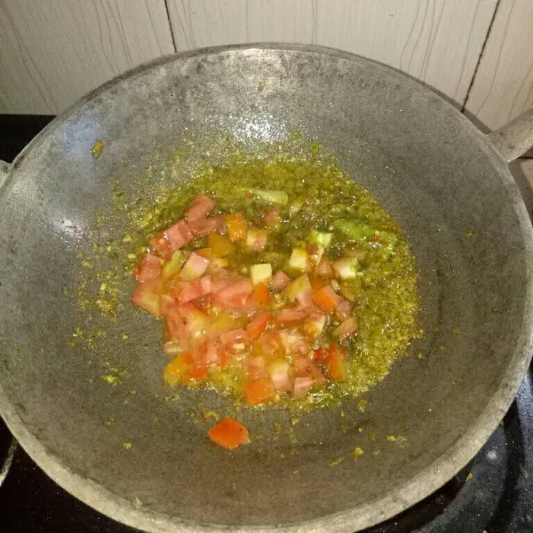 Siapkan pan dan panaskan minyak, tumis bumbu halus sampai harum, masukan tomat dan daun jeruk. Aduk rata.