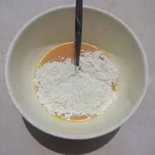 Tambahkan tepung terigu, aduk lagi hingga tercampur.