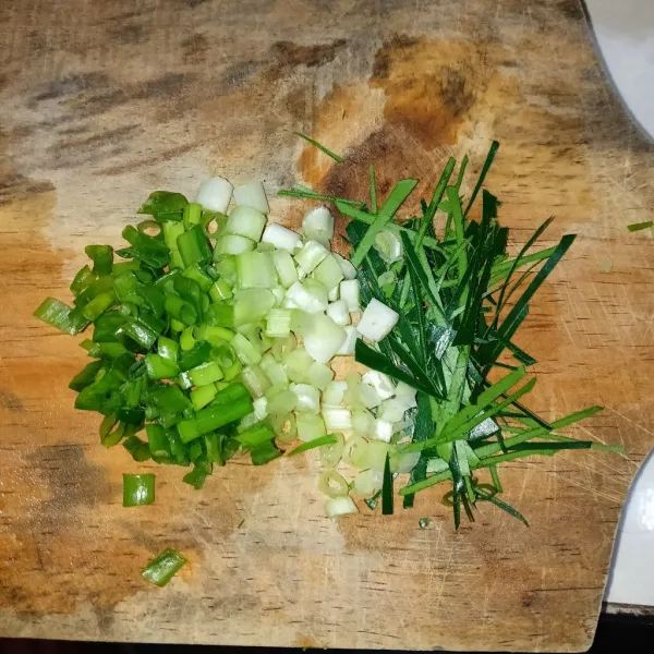 Iris tipis daun jeruk dan daun bawang.