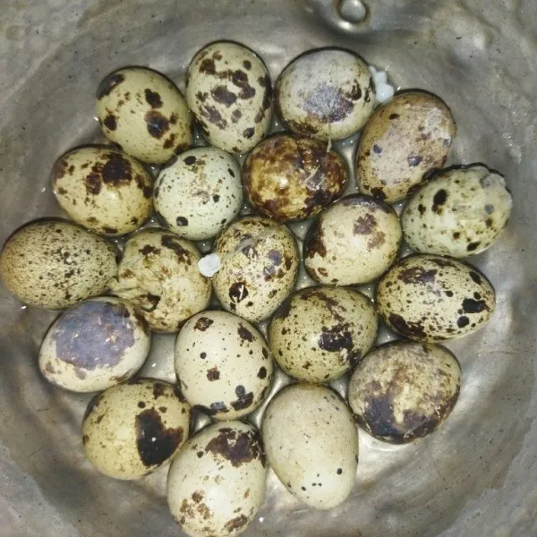 Rebus telur puyuh hingga matang, lalu kupas.