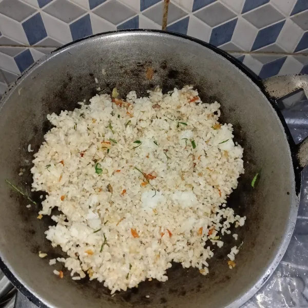 Masukkan nasi yang sudah dingin dan beri seasoning.