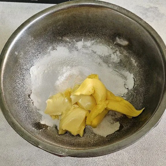 Kocok butte rmix dengan gula halus hingga tercampur rata saja jangan sampai mengembang. Setelah itu masukkan kuning telur. Aduk rata.