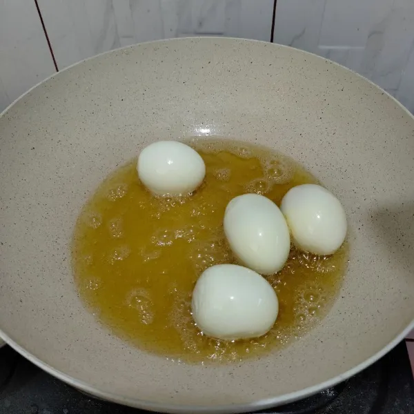 Goreng telur yang sudah direbus hingga berkulit.
