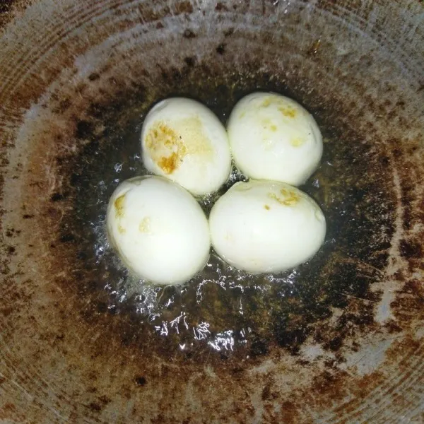 Rebus telur lalu goreng telur hingga berkulit.