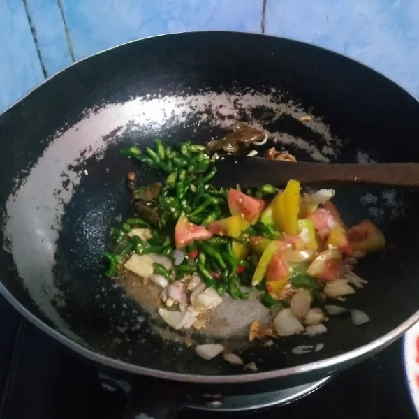 Masukkan cabe hijau dan tomat, masak layu.