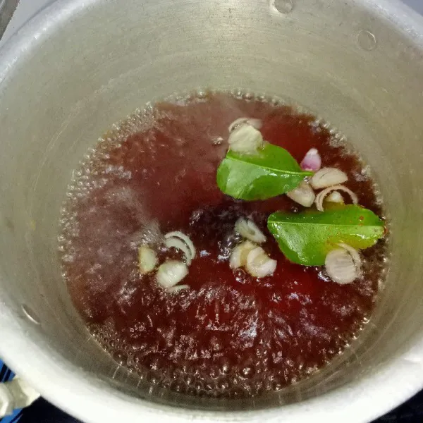 Masukkan air ke dalam panci tambahkan gula pasir, bawang yang sudah diiris, daun jeruk, serai rebus sampai mendidih.