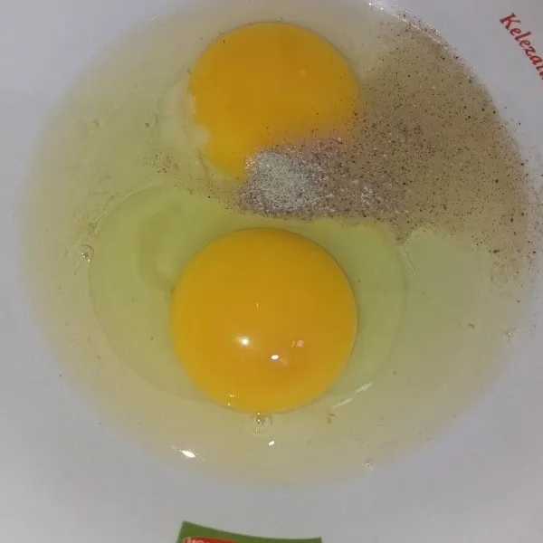 Pecahkan telur di dalam mangkuk tambahkan lada, kaldu jamur dan garam.