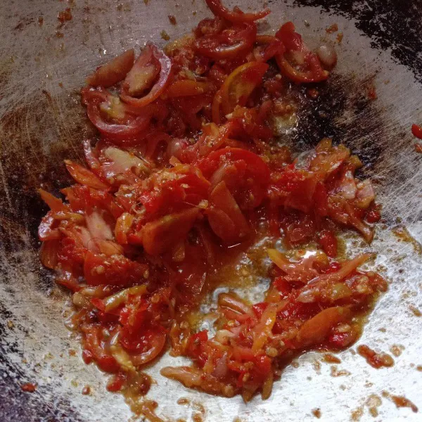 Masukkan irisan tomat, aduk terus hingga tomat hancur.