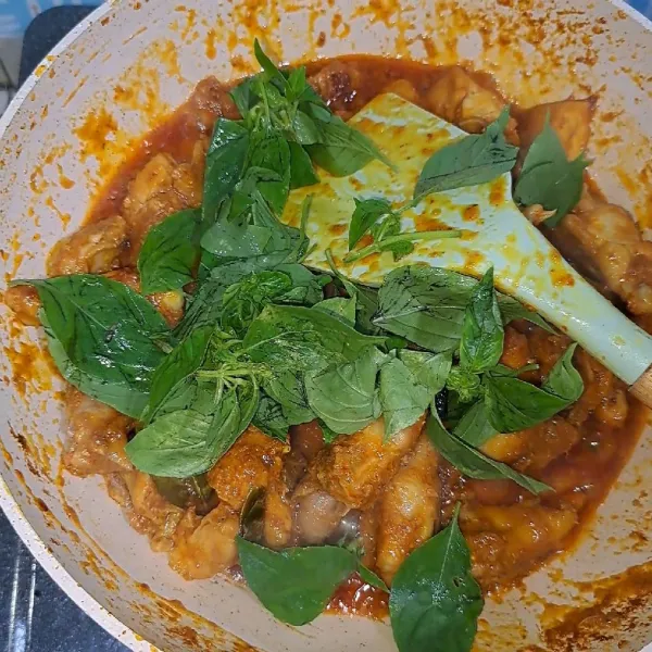 Setelah ayam empuk dan air sudah surut masukkan kemangi, aduk sebentar lalu matikan kompor.