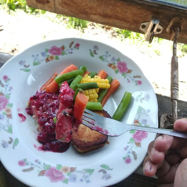 Sajikan steak tempe dengan pelengkap sayuran dan saus merah. Siap dinikmati.