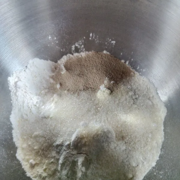 Masukkan tepung terigu, gula pasir, dan ragi ke dalam mixer, aduk dan mixer sambil masukkan air es secara perlahan. Mixer setengah kalis lalu masukkan garam dan mentega, mixer kembali hingga kalis.