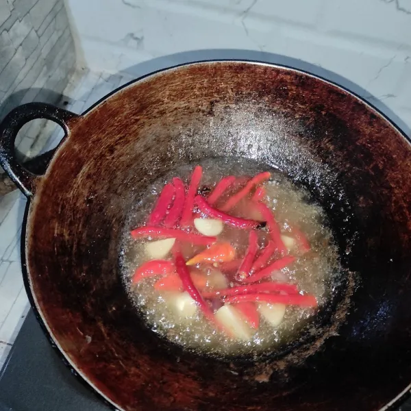Goreng cabai, bawang merah dan bawang putih dengan minyak sisa menggoreng cumi tadi sampai matang. Angkat.