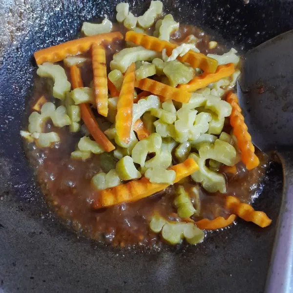 Masukkan pare, wortel, aduk rata dan masak hingga matang.