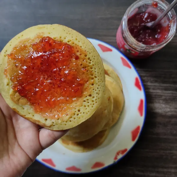 Oles pancake dengan selai strawberry, sajikan.