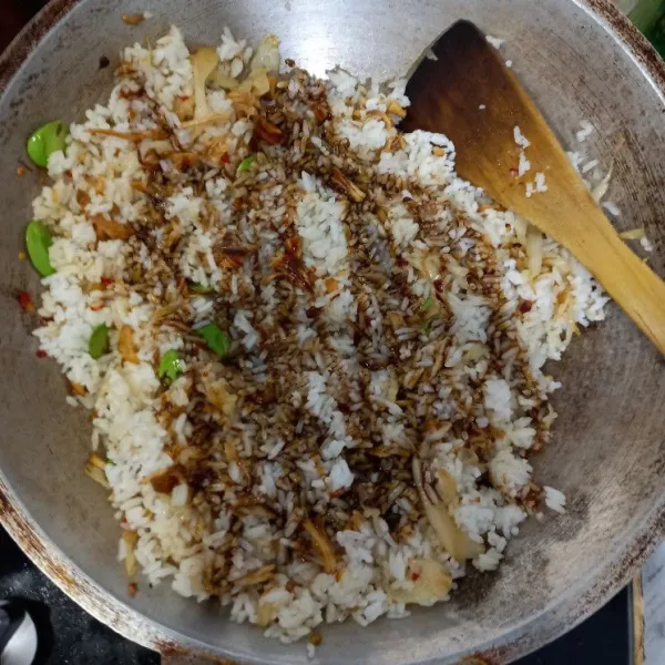 Masukan nasi aduk sebentar, kemudian tambahkan kecap aduk sampai tercampur rata, masak hingga matang.