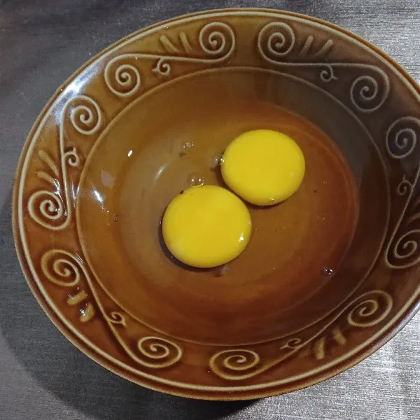 Pecahkan telur di wadah.