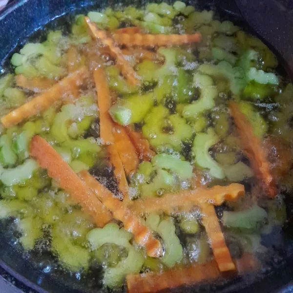 Panaskan minyak sayur dengan api sedang dan goreng pare, wortel sesaat, sisihkan.