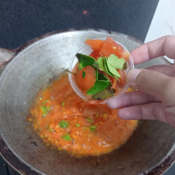 Masukkan tomat yang diiris dan daun jeruk purut.