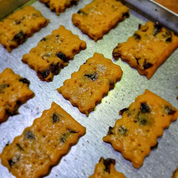 Tata di oven dan tusuk-tusuk permukaan biscuit dengan garpu lalu taburi dengan gula pasir.