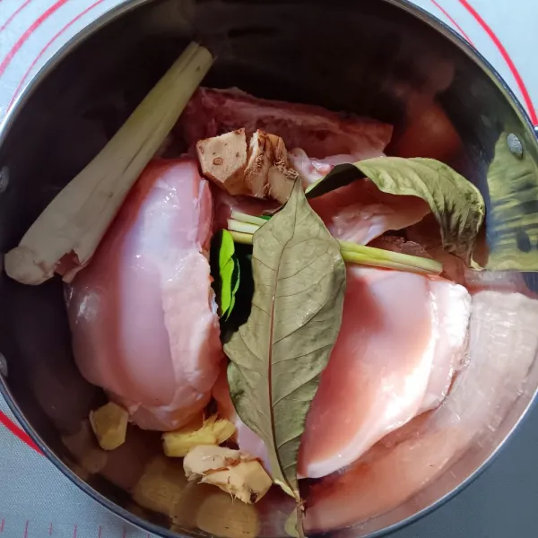 Masukkan ayam kedalam panci, tambahkan daun salam, daun jeruk, jahe, lengkuas dan sereh.