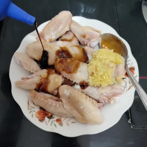Masukkan ayam ke dalam piring/wadah. Tambahkan bawang putih, kecap asin, kecap manis, saus tiram, dan minyak wijen.