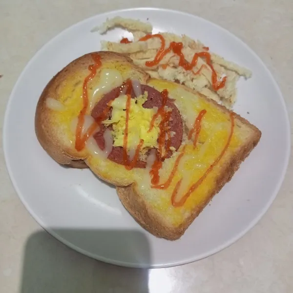 Letakkan juga sisa roti yang sudah dilubangi, tambahkan saus sambal dan mayonaise.