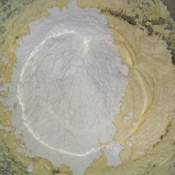 Tambahkan tepung terigu sambil diayak.