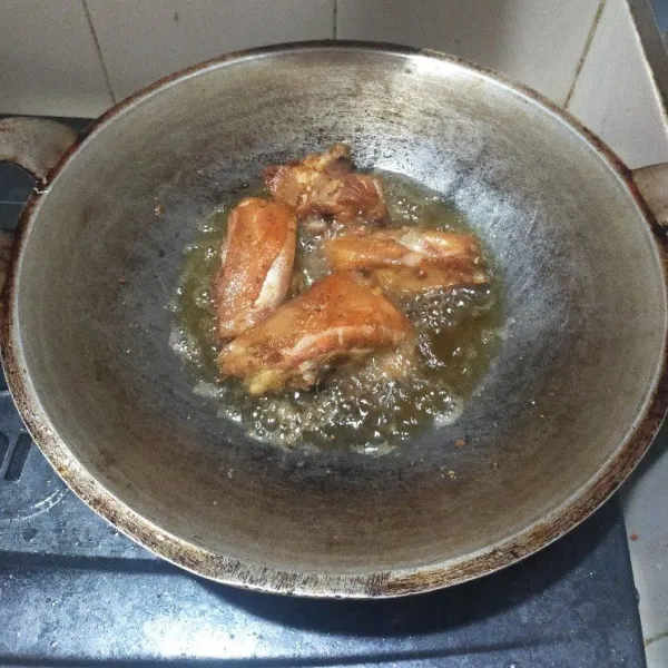 Goreng ayam yang sudah selesai di ungkap dengan api sedang.