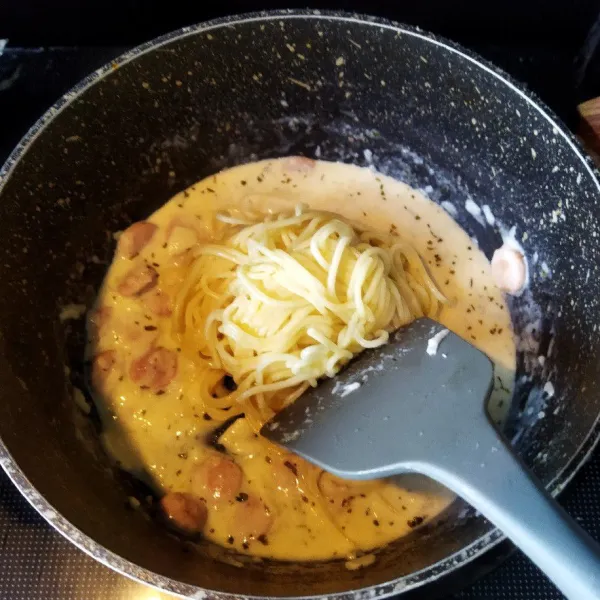 Setelah keju meleleh masukkan spaghetti yang telah ditiriskan, aduk hingga tercampur rata.