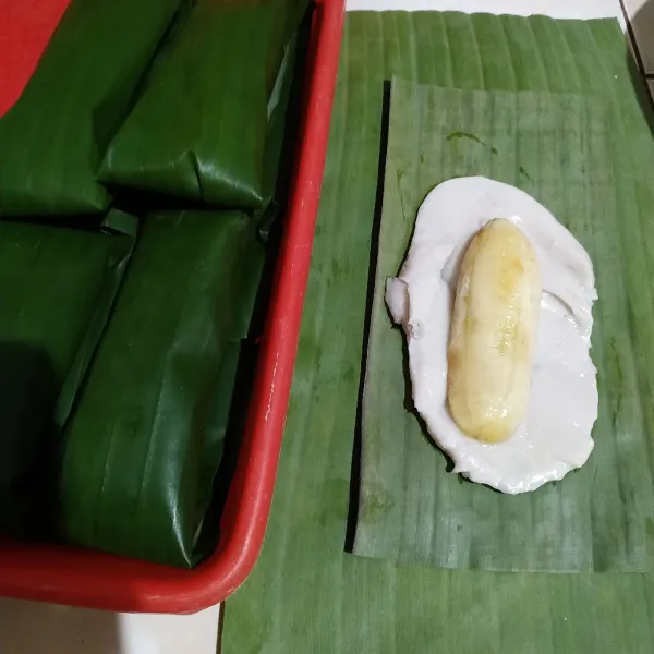 Bungkus adonan dan pisang dengan menggunakan daun pisang. Bentuk bungkusan sesuai selera.