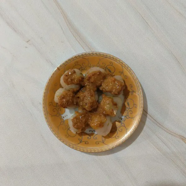 Siapkan cilok dalam piring saji, lalu siram dengan saus kacang. Taburi dengan bawang goreng. Sajikan.