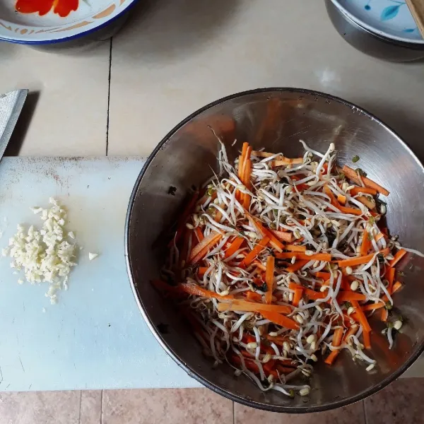 Cincang bawang putih, potong korek api tipis wortel, iris seledri. Campurkan tauge, wortel dan seledri, cuci dan tiriskan.