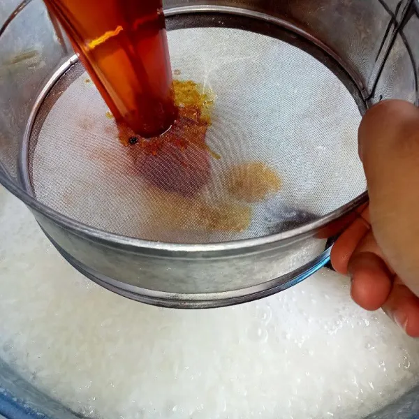 Setelah air beras ketan sedikit berkurang tuang air gula sambil disaring.