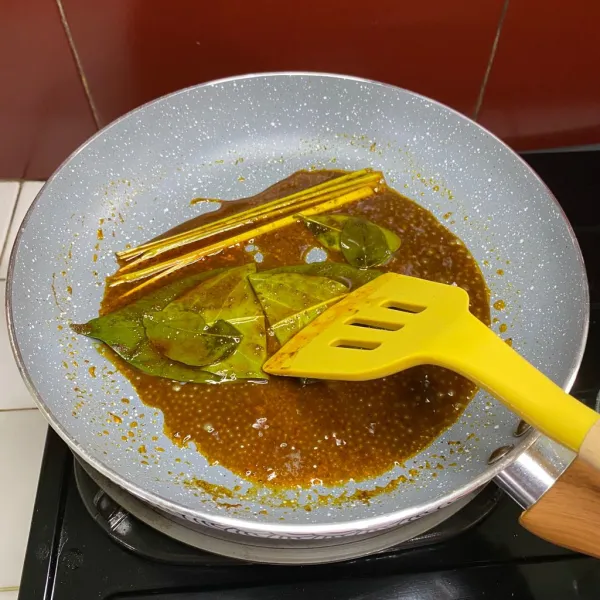 Tumis bumbu rendang instan, lalu tambahkan daun salam, daun jeruk dan sereh.