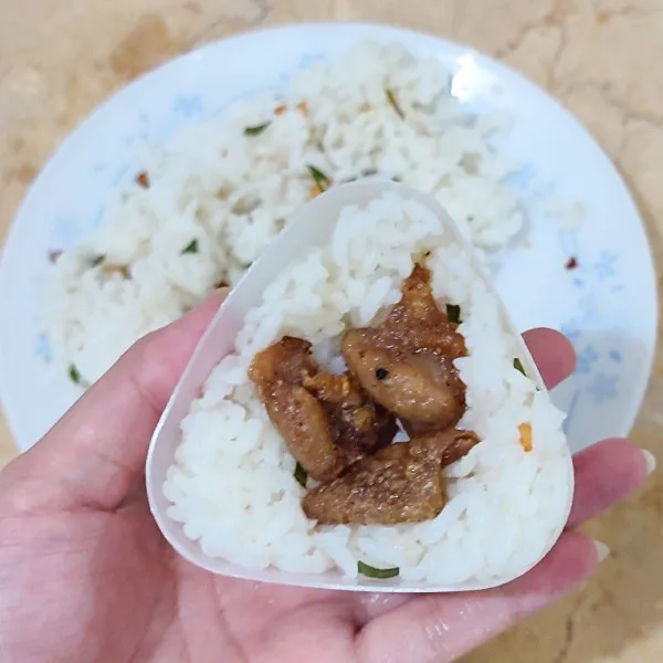 Bentuk nasi kedalam cetakan onigiri (jika ada) berikut isi kulit ayam crispy. Dapat dibentuk menggunakan tangan jika tidak ada cetakan.