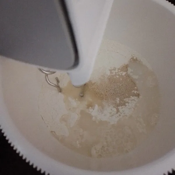 Masukkan air sedikit demi sedikit ke dalam tepung sambil dimixer, mixer hingga adonan setengah kalis.