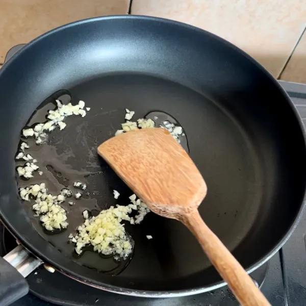 Tumis bawang putih sebentar menggunakan minyak goreng.