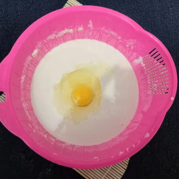Masukkan satu butir telur dan minyak goreng, kemudian aduk hingga tercampur rata.